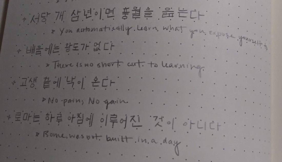 Korean proverbs in a dotted notebook, each with an English line under it