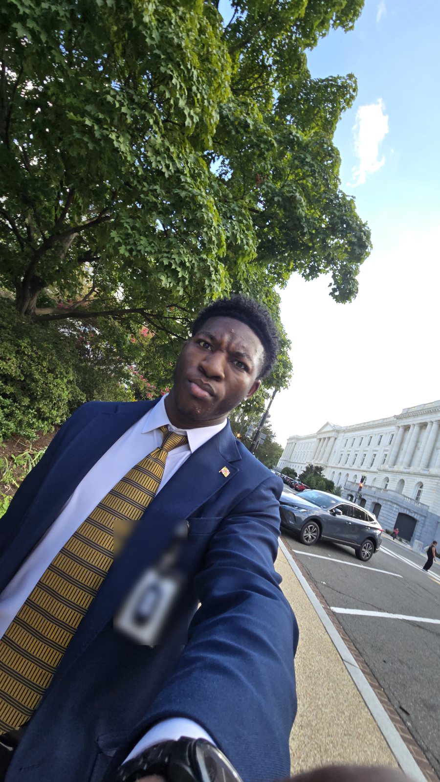 Ademola making a face in a selfie outside a Senate office building