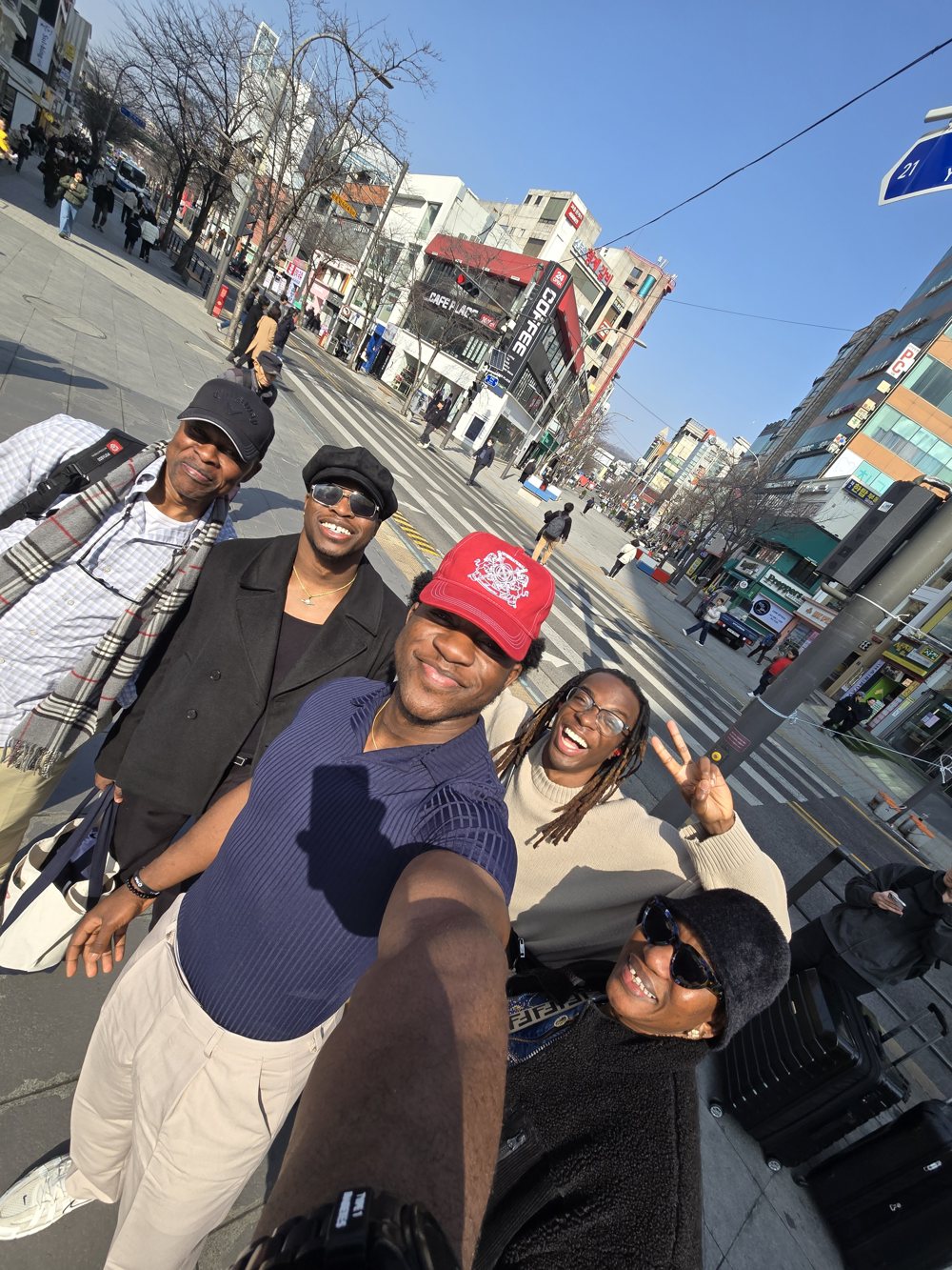 Ademola's family in a selfie on a sunny Seoul street