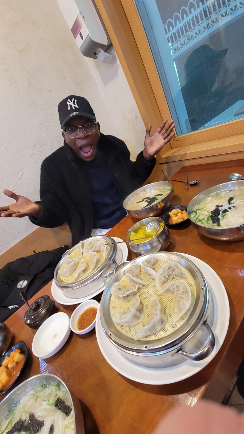 Ade at a table of kalguksu and mandu