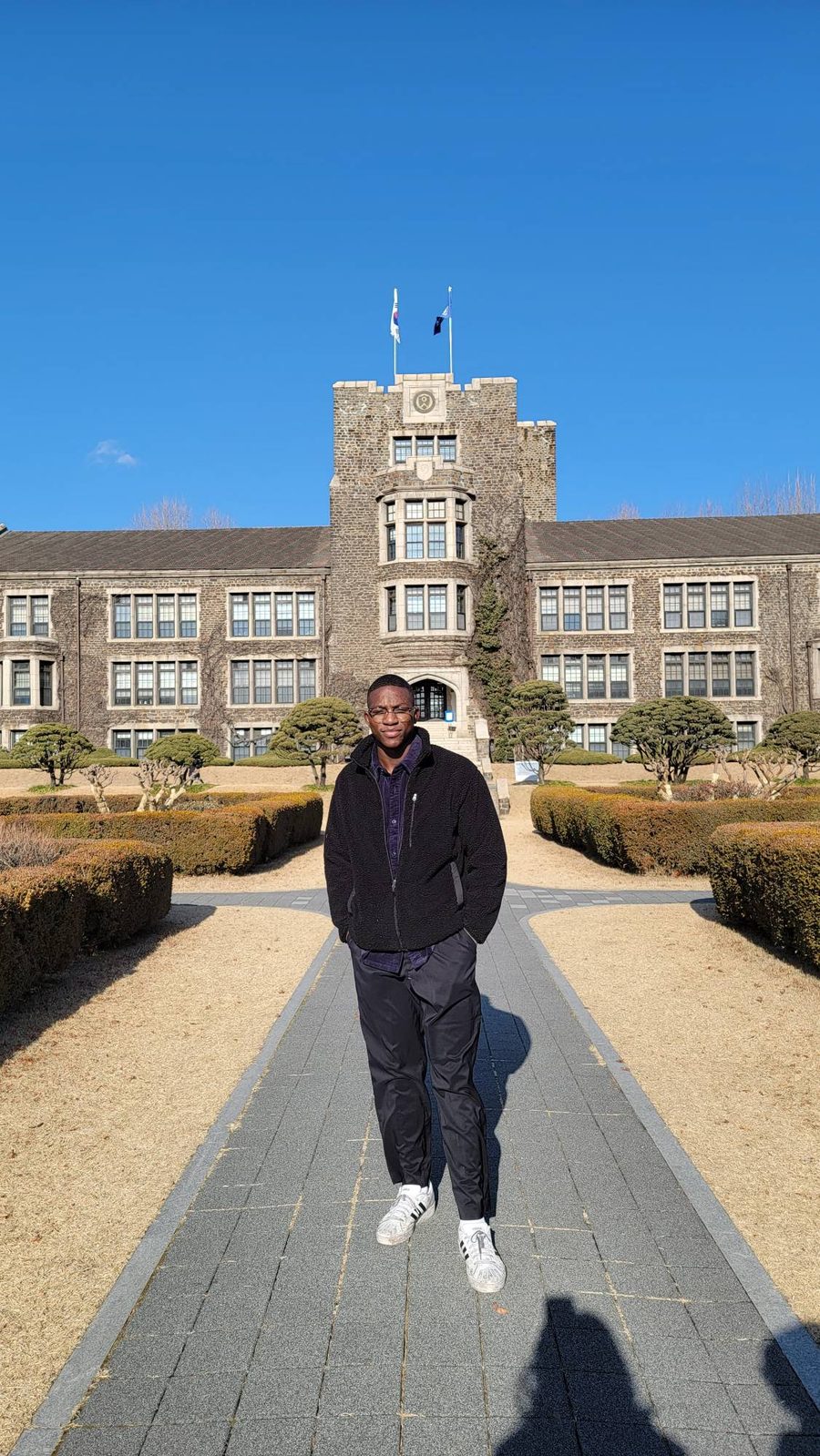Ade standing in front of Yonsei University's main hall